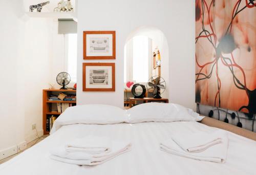 ローマにあるTrastevere Split Level Terrace Apartment - Top Collectionの白いベッド1台付きのベッドルーム1室(壁に絵画付)