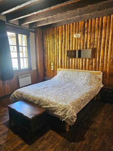 una camera da letto con un letto in una parete di legno di chez Fred a Saint-Rambert-en-Bugey