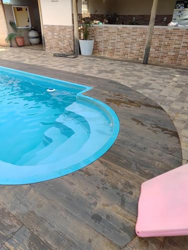 a swimming pool with a pink chair next to it at Chalésforquilha in Delfinópolis