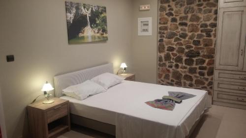a bedroom with a bed and a stone wall at Villa Sotiriou in Limne