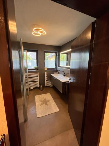 a bathroom with a tub and a sink and a mirror at Wunderschöne, große Gartenwohnung mit 3 Schlafzimmern Nähe Kaufbeuren in Untergermaringen