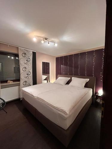 a bedroom with a large white bed and a window at Wunderschöne, große Gartenwohnung mit 3 Schlafzimmern Nähe Kaufbeuren in Untergermaringen