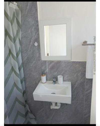 a bathroom with a white sink and a mirror at 60 On Kosmos in Bellville South