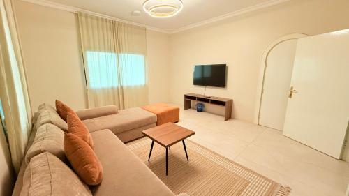 Una sala de estar con un sofá y un televisor. en مثوى, en Medina