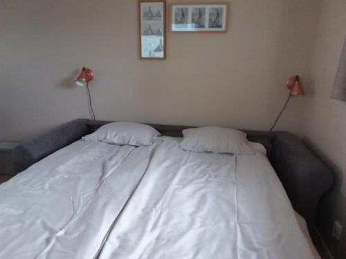 a bed with two pillows on it in a room at Furusol Borgholm in Borgholm