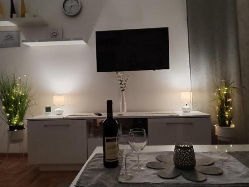 a bottle of wine sitting on a table with two wine glasses at Predo Apart in Zlatibor