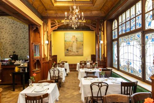 una sala da pranzo con tavoli, sedie e finestre di Hotel Rubenshof ad Anversa