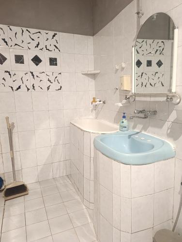 a white bathroom with a sink and a mirror at Gamsakhurdia Street in Borjomi