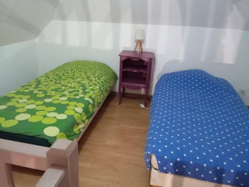 a bedroom with a bed and a table with a night stand at Gîte des pins 1 et 2 personnes in Saint-Martin-au-Bosc