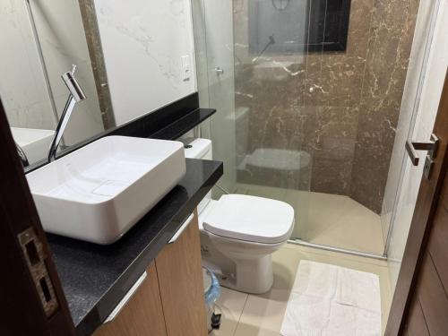 a bathroom with a sink and a shower and a toilet at Atlântico Flat - Praia de Ponta Negra - Natal in Natal