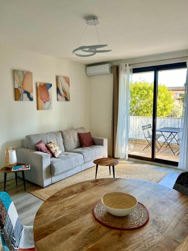 a living room with a couch and a table at 2 pièces, moderne et lumineux avec piscine en résidence privée in Villeneuve-Loubet