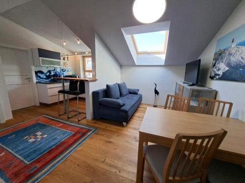 a living room with a table and a blue couch at Apartment Niesenpoint in Albersdorf