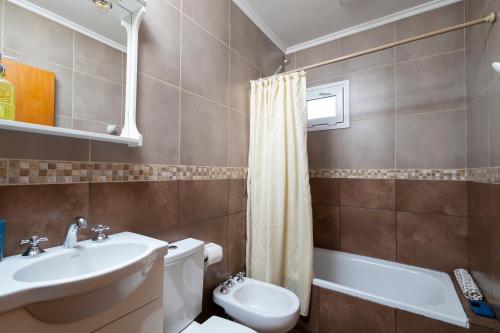 une salle de bain avec un lavabo, des toilettes et une baignoire dans l'établissement Complejo Turistico Paralelo 42, à Lago Puelo