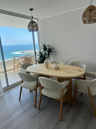 a dining room with a table and chairs and the ocean at Moderno depa con vista al mar Playa El Laucho in Arica