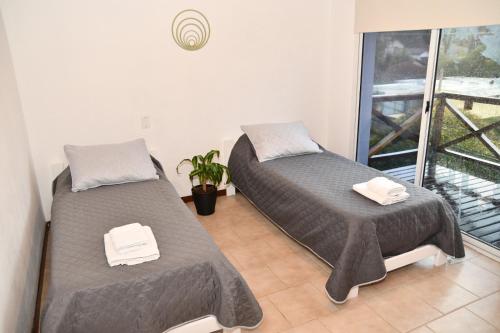 two beds in a room with a balcony at Tangerina Apart Hotel - Villa Gesell in Villa Gesell