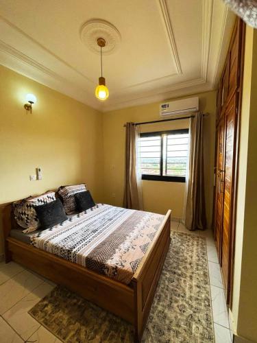 a bedroom with a large bed with a window at Résidence Eden in Yaoundé