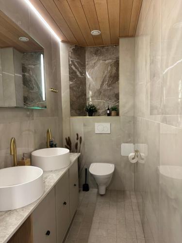 Un baño con dos lavabos y un inodoro. en Premium Private Villa Snowest, en Kivitaipale