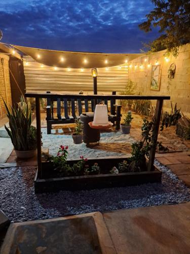 a patio with a bench and a table and lights at Departamento en San Quintín BC in San Quintín