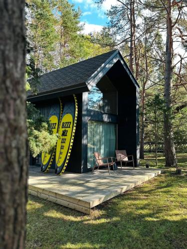 czarny domek ze stołem i krzesłami w obiekcie Bird nest w mieście Undva