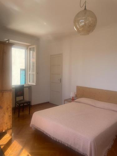 a bedroom with a white bed and a window at Casa Terrazzino - 50 m dal mare in Bordighera