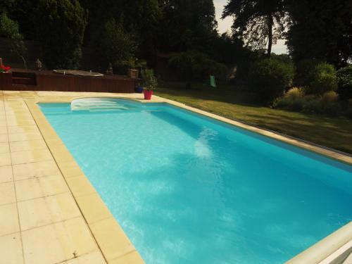 a swimming pool with blue water in a yard at Villa La Clef Des Champs in Chailly-en-Bière