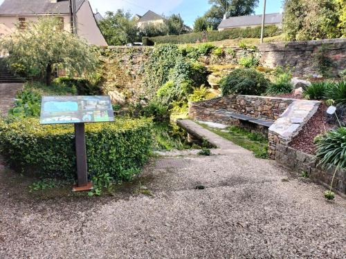 Un cartel delante de un jardín con un banco. en Bel appartement rénové, en Langon