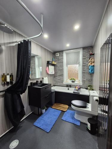 a bathroom with a tub and a toilet and a sink at Ta'Pinu House and Spa in Horse Isle