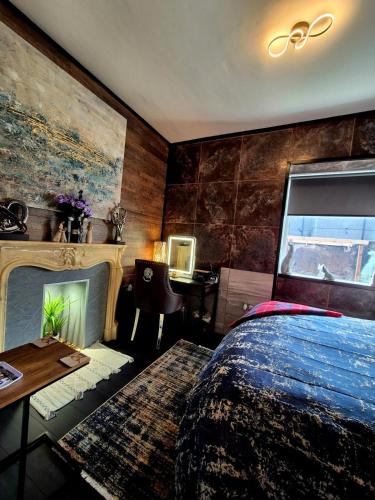 a bedroom with a bed and a fireplace and a desk at Ta'Pinu House and Spa in Horse Isle