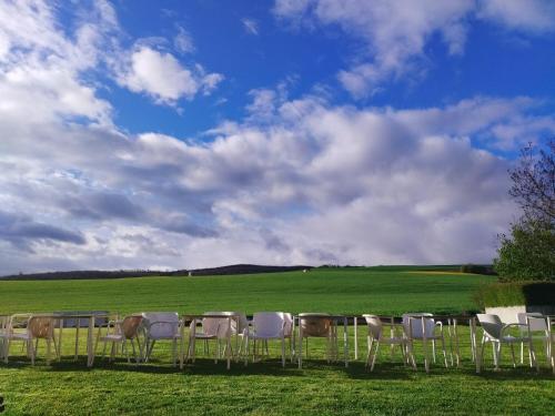 a group of chairs and tables in a field at Casa de los deseos in Villambístia
