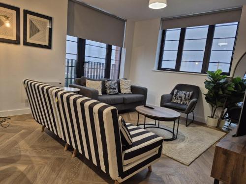 a living room with chairs and a couch and a table at Serene- Stunning Two Bedroom 2 washroom, Spacious, dual aspect lounge, Jwellery Quarter, Birmingham City Centre in Birmingham