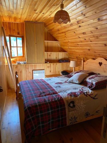 a bedroom with a bed in a wooden cabin at Chalet typique des Pyrénées in Boutx