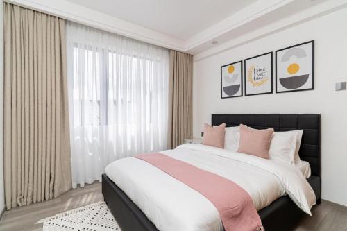 een slaapkamer met een groot bed en een groot raam bij Gatundu Heights in Nairobi
