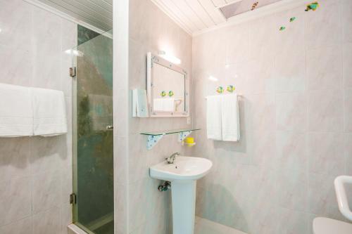 a white bathroom with a sink and a shower at Casa do Cais in Calheta