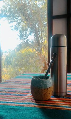 een kom met een lepel erin naast een thermoskan bij Villa Shambhala in Salsipuedes