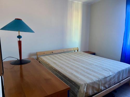 a bedroom with a bed and a lamp on a table at Etna e mare per il tuo relax in Villaggio San Leonardo