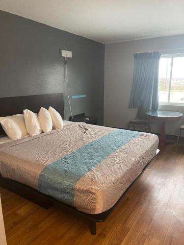a bedroom with a bed and a table and a window at TROYINN&SUITES in Troy