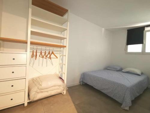 Un dormitorio con una cama y una estantería. en La cigala, en Le Pradet