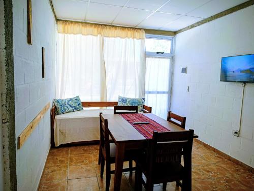 a room with a table and a bed and a couch at Lavanda y Romero Villa Yacanto de Calamuchita in Villa Yacanto
