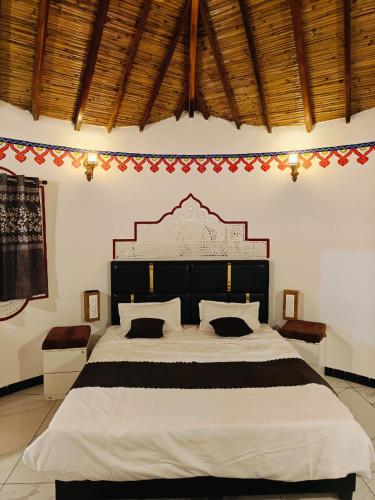 a bedroom with a large bed with a large headboard at Dholavira Desert Homestay in Dholovira