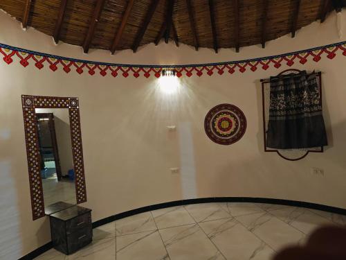 a room with a mirror and decorations on the wall at Dholavira Desert Homestay in Dholovira