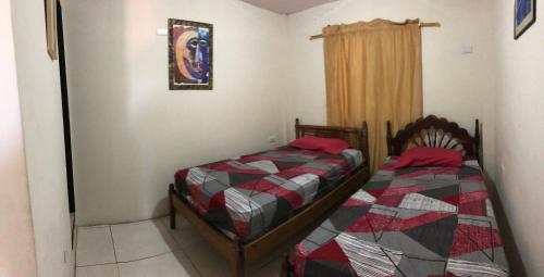 a bedroom with two beds and a window at Hospedaje Maluli suit 4 in Santa Elena