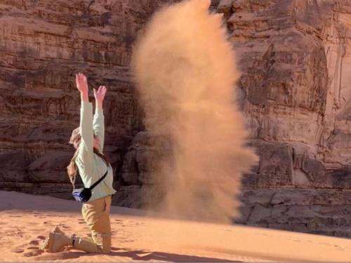 アカバにあるWadi Rum Marchの砂漠に手を上げて立つ者