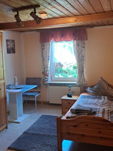 Un dormitorio con una cama y un escritorio y una ventana. en Gästehaus Ulrike, en Steinberg