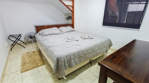 a bedroom with a bed with a table and a table at Departamento Oberá-1 in Oberá