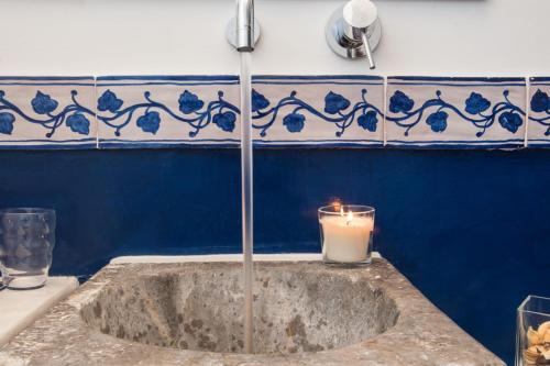 a candle sitting on a sink with a blue wall at L'Opera Buffa in Palermo