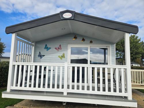 a small house with butterflies on the side of it at Haven Golden Sands Holly Drive 24 in Mablethorpe
