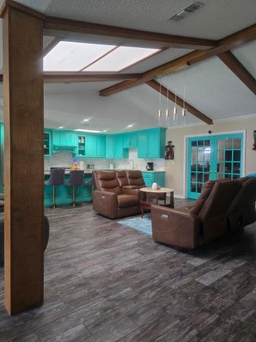 sala de estar con 2 sofás marrones y cocina en 5BR3BA Home, 2 Blocks from Beach, ADA Accessible, en Galveston