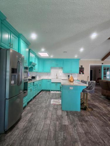a kitchen with blue cabinets and a refrigerator at 5BR3BA Home, 2 Blocks from Beach, ADA Accessible in Galveston