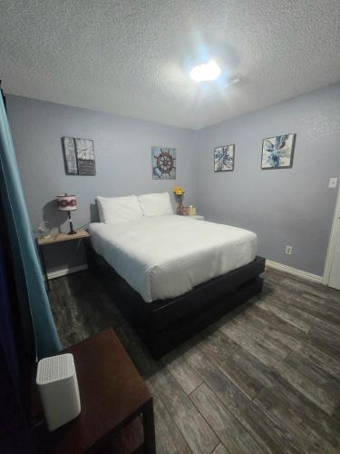 a bedroom with a white bed and a table at 5BR3BA Home, 2 Blocks from Beach, ADA Accessible in Galveston