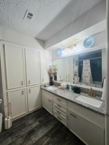 a bathroom with two sinks and a large mirror at 5BR3BA Home, 2 Blocks from Beach, ADA Accessible in Galveston